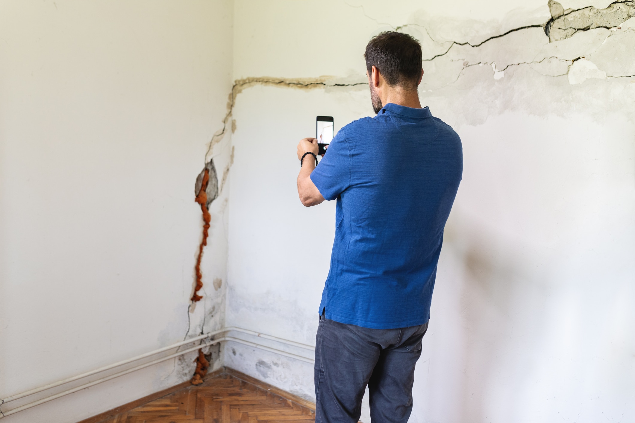 a man standing in front of a blue wall