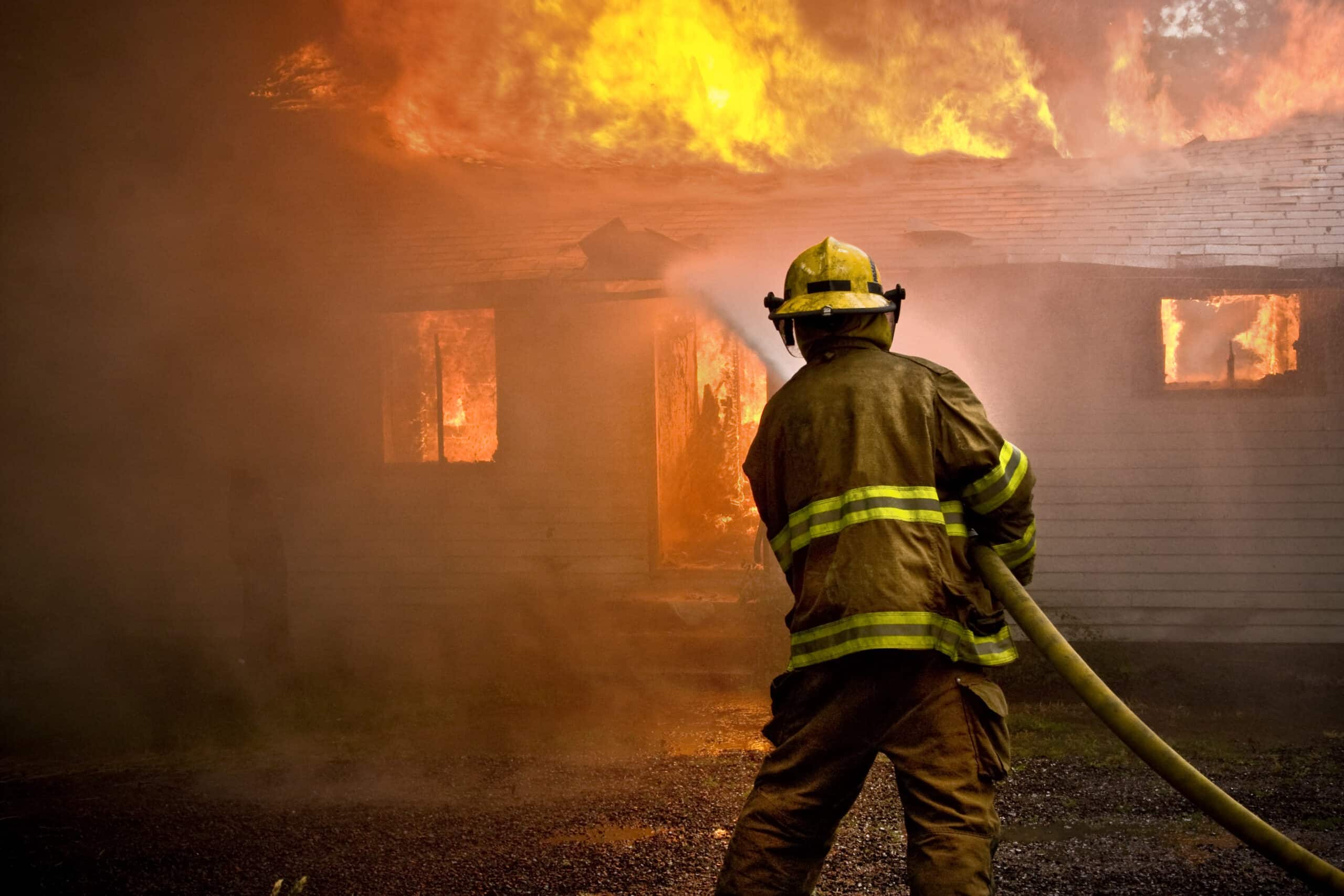 Emergency response members fighting wildfire that has touched houses.