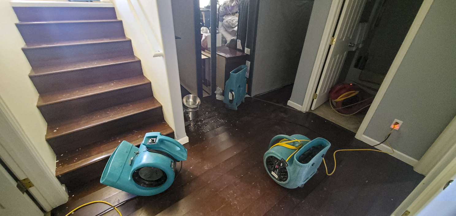 Air movers set in place to dry out a home after a water damage flood caused by a pipe break.