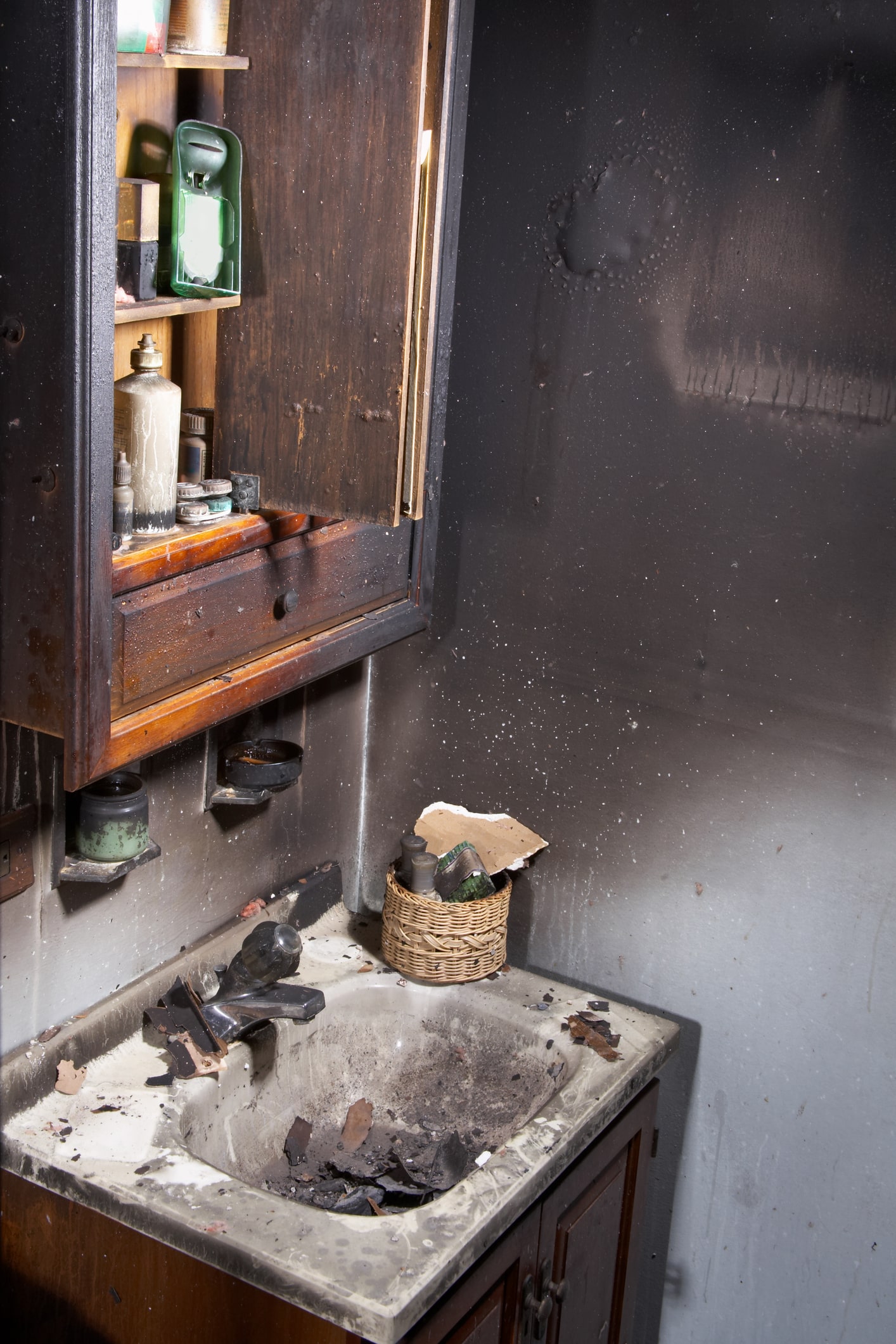 Soot covered bathroom in a house gutted by fire.