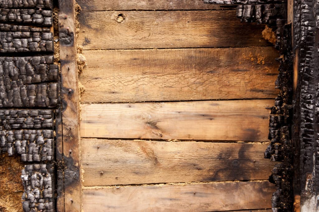 Brown burnt wall of house of wooden planks with embossed texture. background for copy space. concept of loss of real estate or home. property insurance.